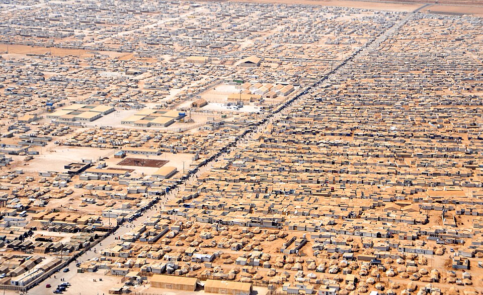 Za'atari camp, Jordan, 2013: shelters in blocks along a straight main street, with open ground kept for services.