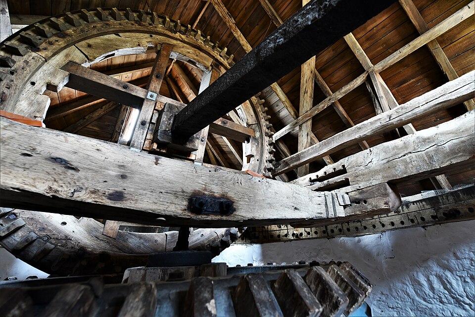 The great brake wheel inside Bembridge mill, Isle of Wight: wooden cogs on a wheel keyed to the windshaft, with the brake band round its rim. One wheel takes all the sails' power, and stopping it is the only brake the mill has.