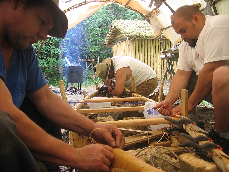 Building a birch-bark canoe, 2009: lashing the bark to the gunwale.