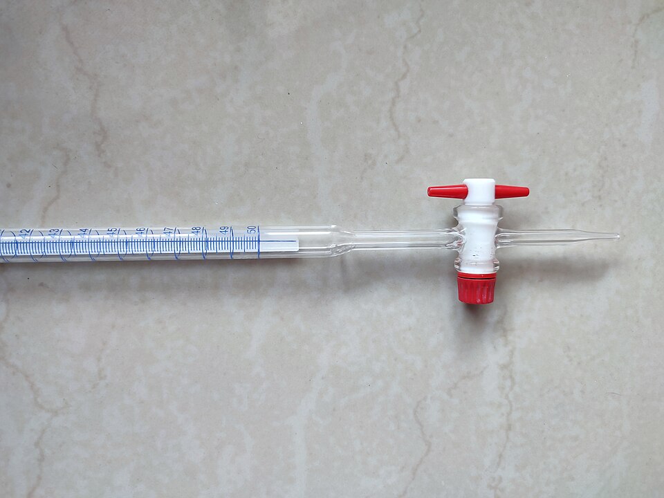 The lower end of a glass titration burette (2025): graduations to 50 mL on a blue Schellbach stripe, which makes the liquid level easy to read, and the tap that lets the thiosulphate run in drop by drop.