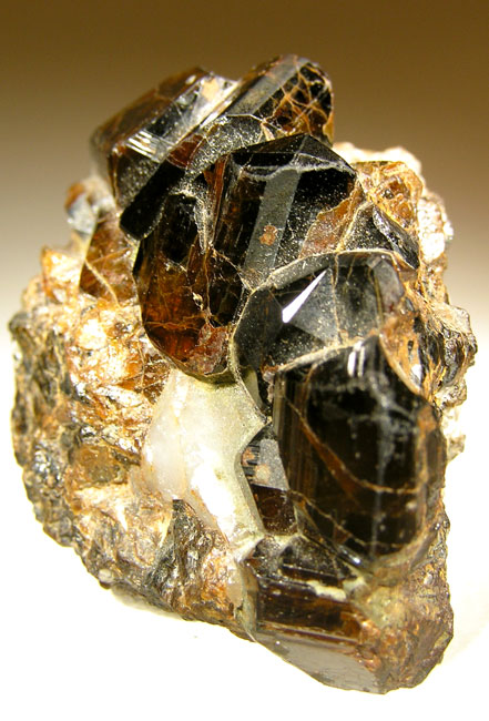 Cassiterite, tin oxide: dark brown to black crystals, very heavy for their size. Worn pebbles of it collect in stream gravels, where most early tin was found.