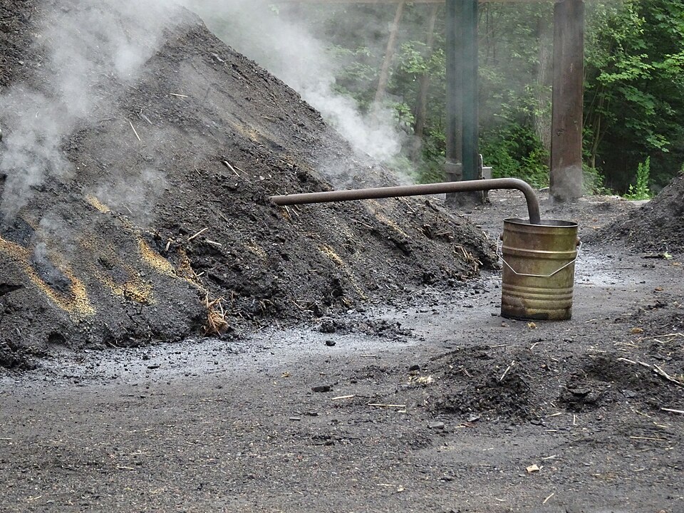 An earthed charcoal clamp part-way through its burn.
