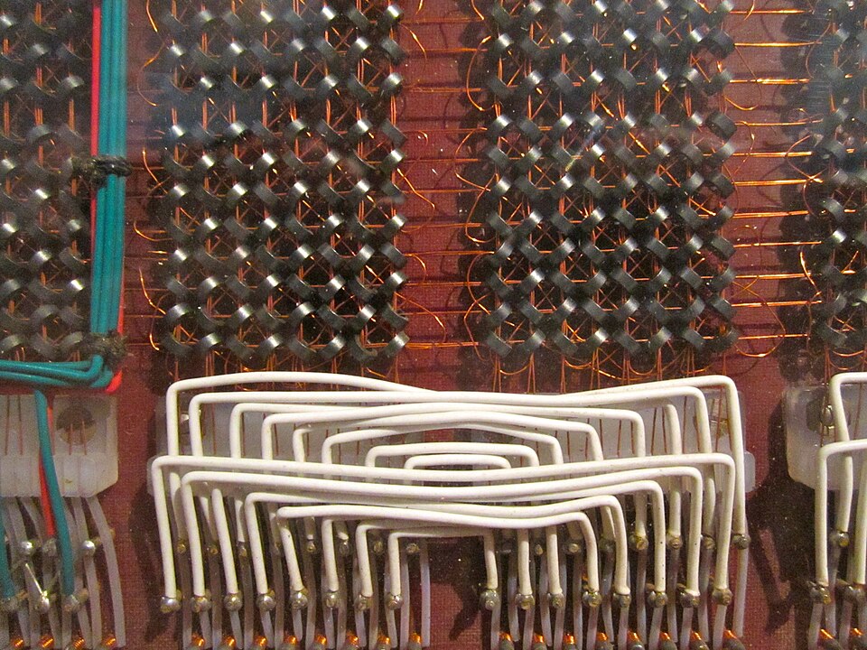 Ferrite-core memory from a 1960s Electrologica X1 computer. Each small dark ring, threaded on crossing wires, stores one bit as the direction of its magnetisation, and keeps it with the power off.