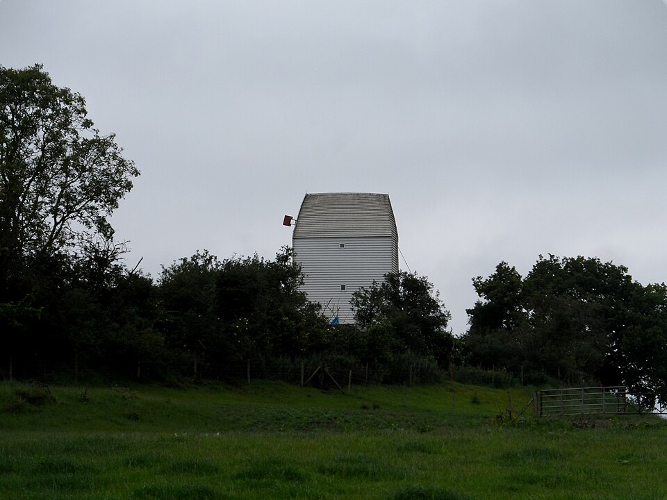 The buck of the post mill at Drinkstone, Suffolk, photographed without its sails. The whole body — frame, stones, gearing and miller — turns on the single oak post beneath it.