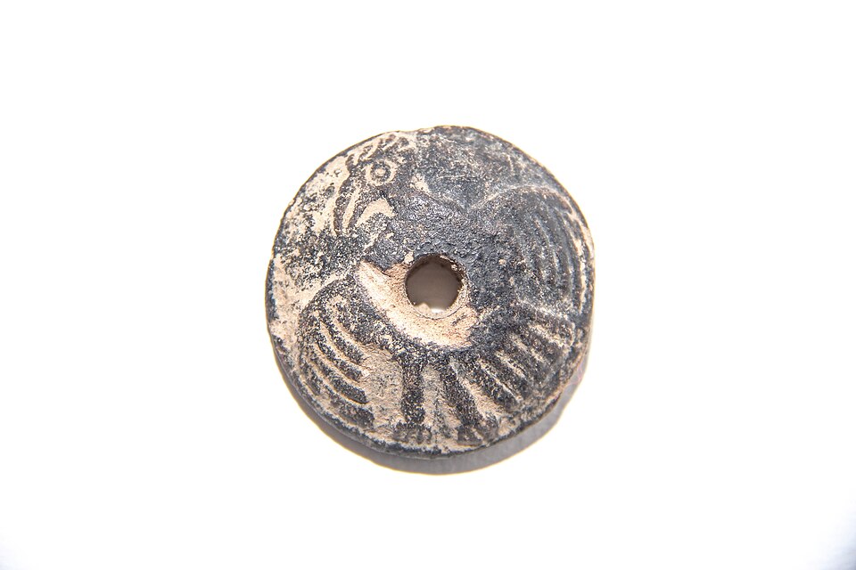 A clay spindle whorl from Mexico. Fixed on a shaft, its weight keeps the spindle turning, and the spin is what puts twist into yarn.