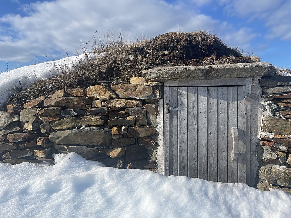 A turf-roofed stone root cellar built into a slope at Elliston, Newfoundland.