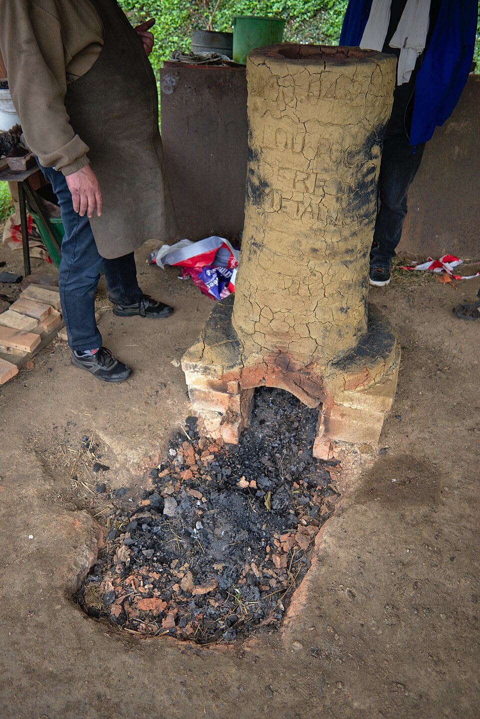 A clay bloomery shaft after a smelt, with the slag pit in front of the tap.