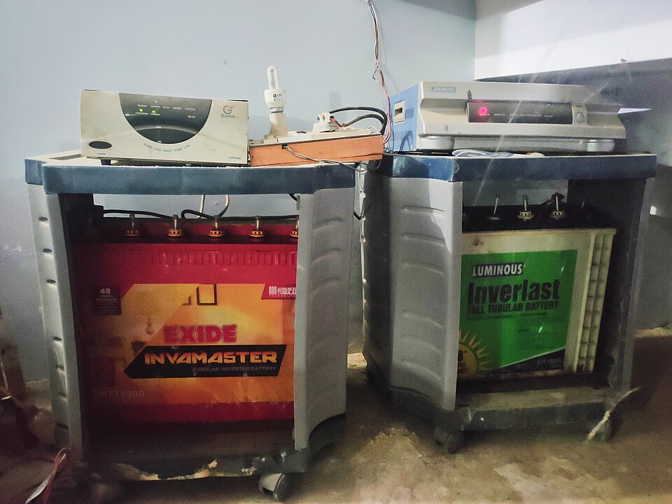 A household backup system in India: two lead-acid batteries on trolleys, each with an inverter on top that charges it from the grid and runs the house through power cuts.