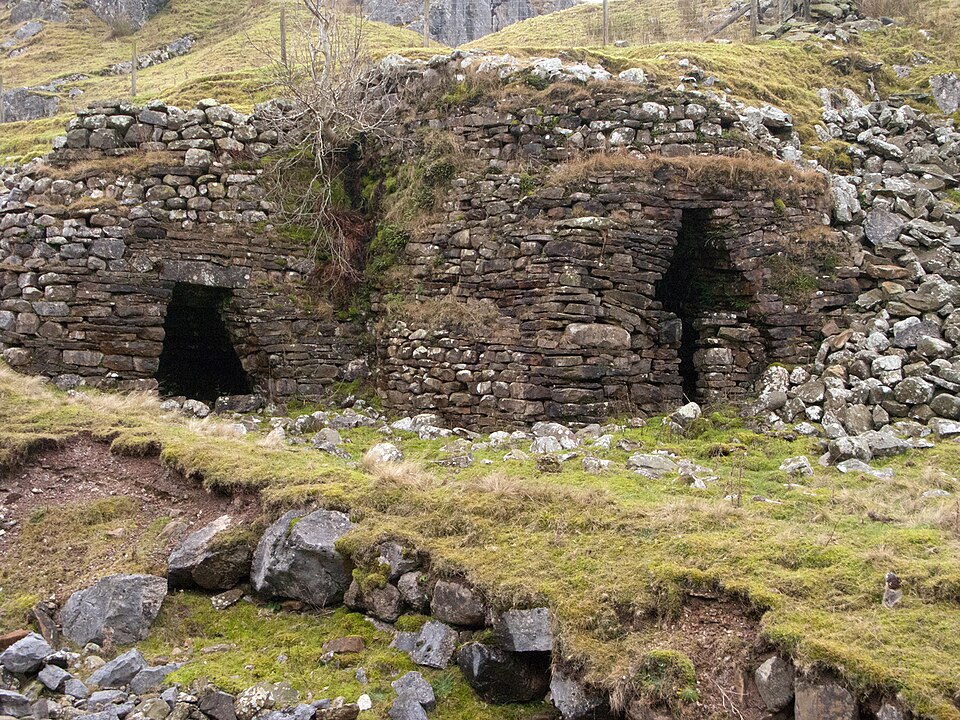 A twin-eyed limekiln bank — charged from the top of the slope, drawn from the arches below.