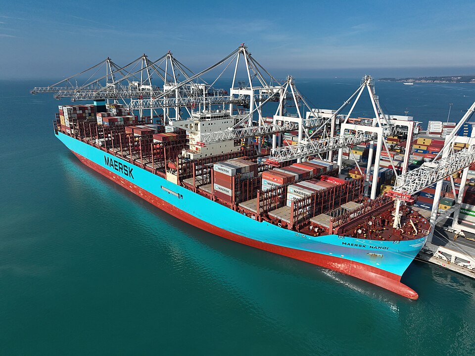 A container ship alongside at Koper, Slovenia, 2023, with the quay cranes over its stacks of standard boxes.