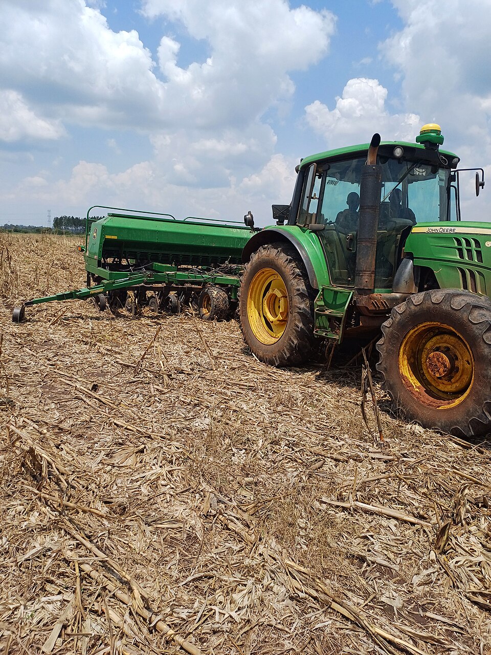 A no-till drill sowing straight into the previous crop's residue (2024): the soil is not ploughed and the stubble stays on the surface as a mulch.