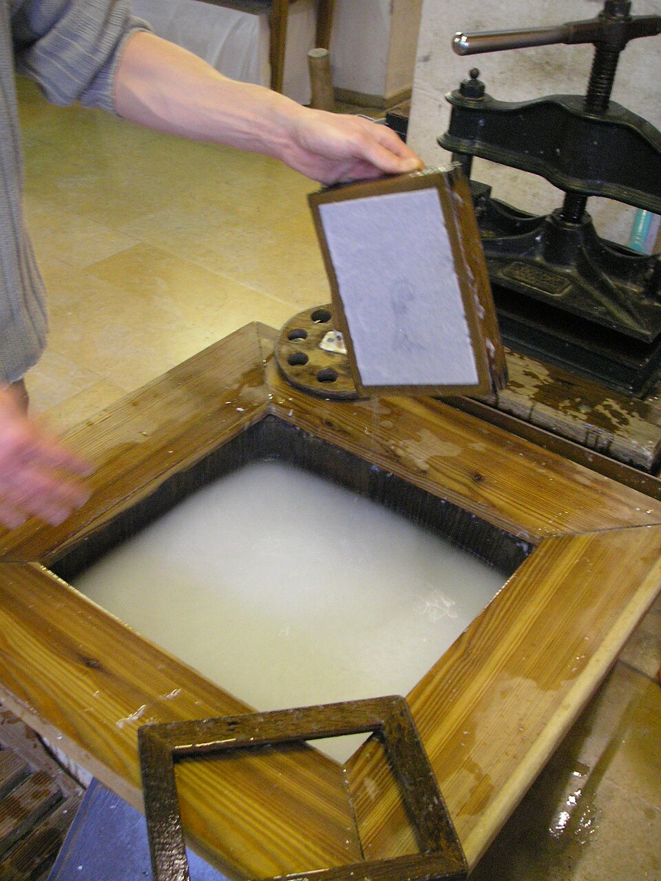 Lifting a sheet from the vat. Cheap paper is what makes cheap knowledge possible.