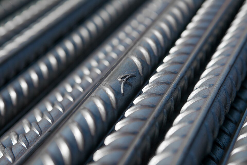 Rolled steel reinforcing bar. Iron becomes structural once carbon and heat treatment are controlled.