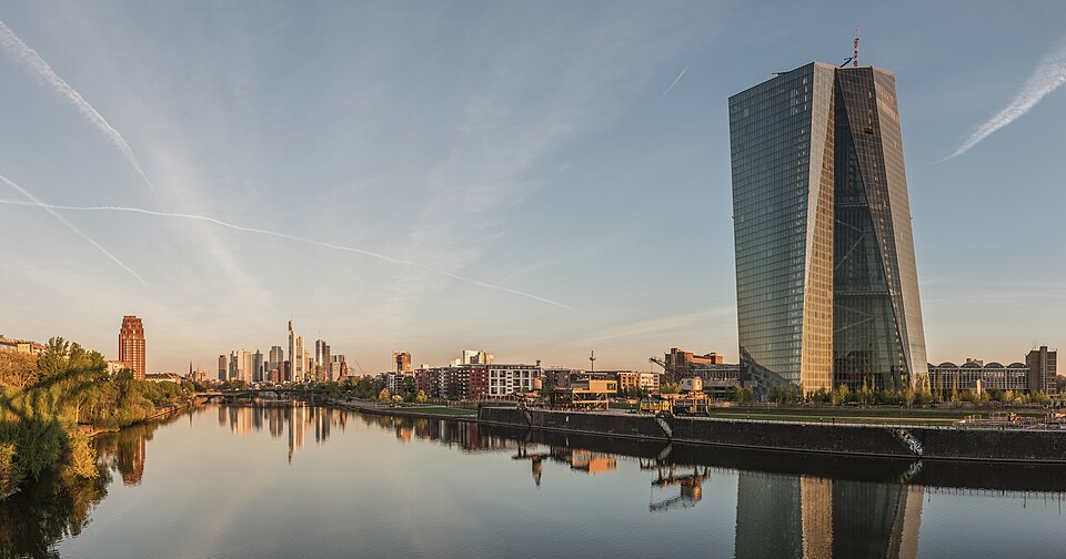 The seat of the European Central Bank beside the River Main, with the Frankfurt skyline behind, 2015: the bank sets interest rates for the euro area to hold inflation at 2 % over the medium term.