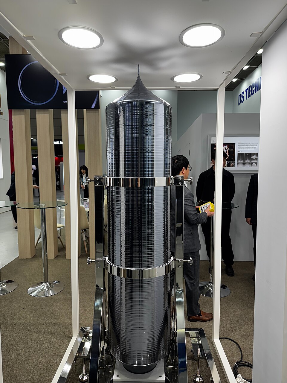 A single-crystal silicon ingot on display, 2025. It was grown by the Czochralski method, pulled slowly and rotating from molten silicon, starting from the thin seed at the pointed top. Wafers are sawn from the cylindrical body.