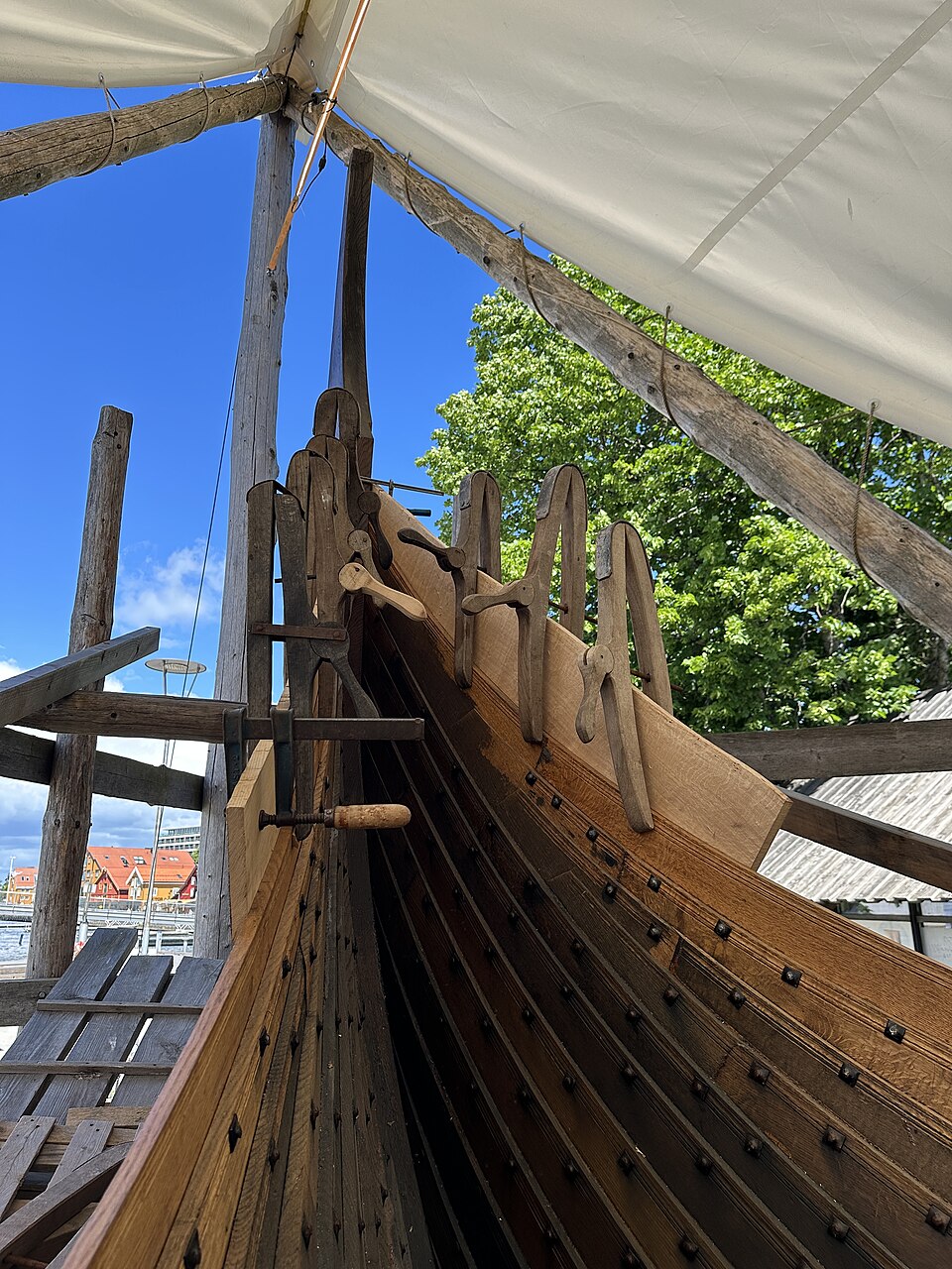 A replica of the Gokstad Viking ship being built in Tønsberg, Norway, 2026: clinker planks overlapping, riveted through the laps and held by frames inside.