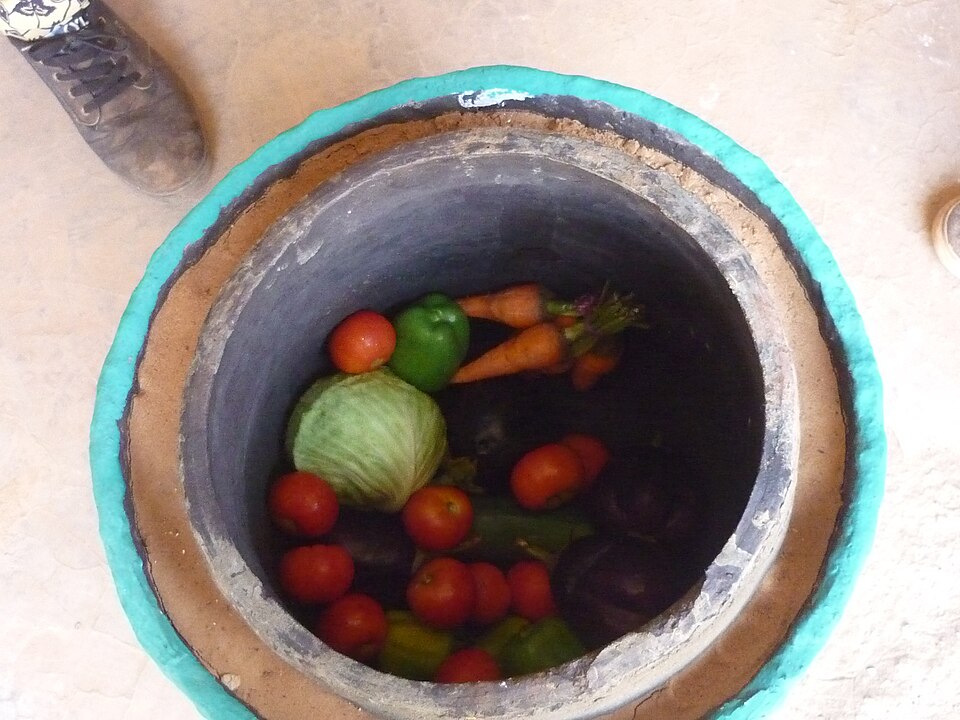 A clay pot cooler: a smaller pot set inside a larger one, the gap packed with sand kept wet. Water evaporating through the outer pot cools the food inside below air temperature — in dry air only.