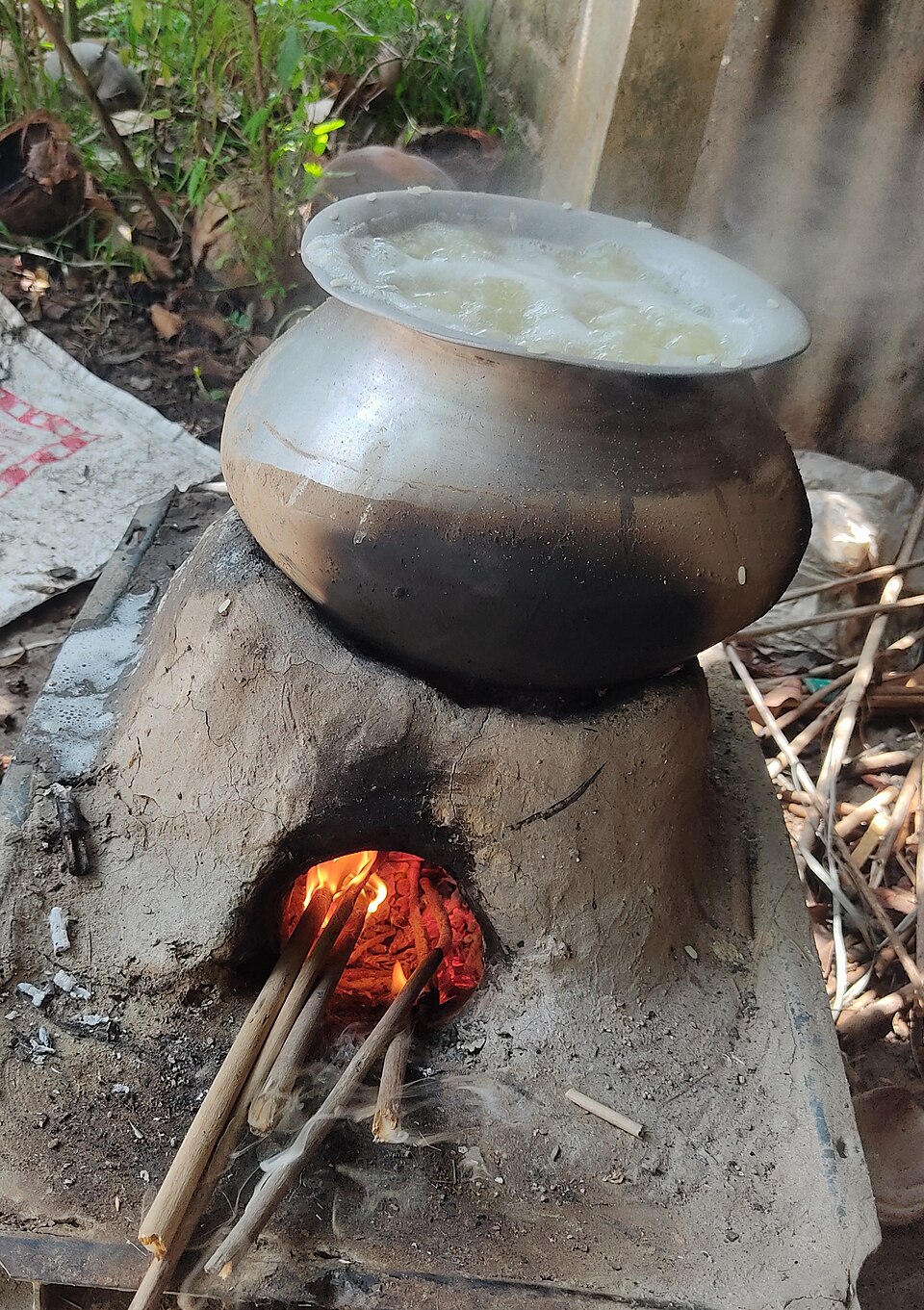 Cooking on a clay stove in the open air in rural Bengal (2025): the smoke disperses outdoors instead of filling a room.