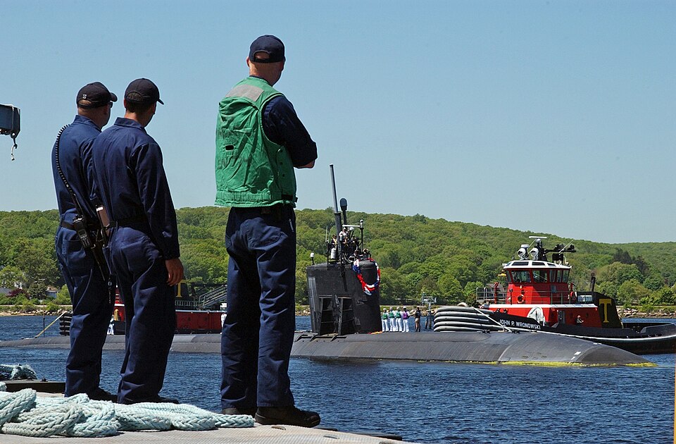 Line handlers wait as the Virginia-class attack submarine USS Hartford comes in on the surface, 2009. Even surfaced, most of the hull sits under water.